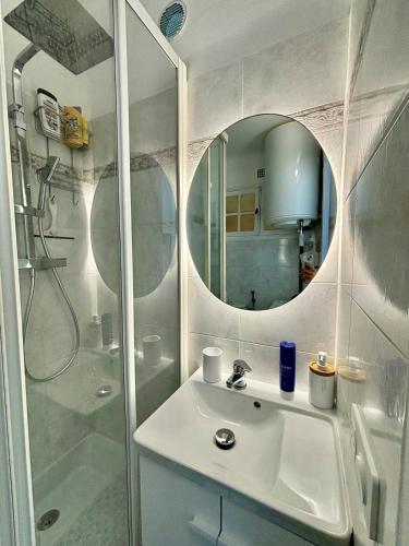 une salle de bain avec un lavabo et une douche avec un miroir dans l'établissement Sea View Studio with Balcony, Near Italy & Monaco, à Menton