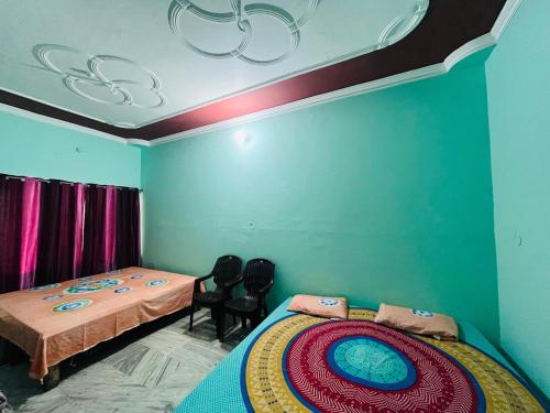 a bedroom with two beds and two chairs in it at Prayag Homestays Cheoki in Prayagraj