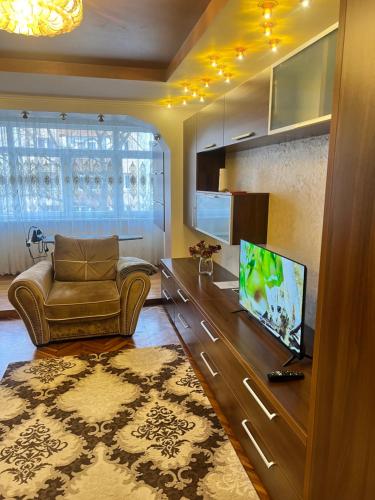 a living room with a couch and a flat screen tv at Bella space in Suceava