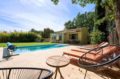 Un patio con sillas y una piscina. en La Velleronnaise, en Velleron
