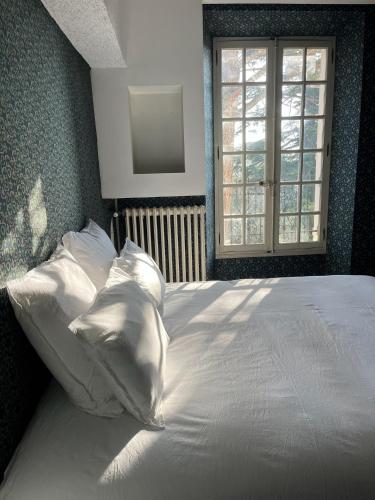 a bed with white sheets and pillows in a bedroom at Mas Provençal Luxe - Piscine et parc classé in Avignon