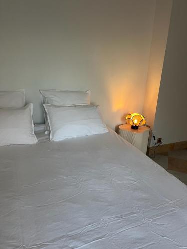 a large white bed with a lamp on a side table at Mas Provençal Luxe - Piscine et parc classé in Avignon