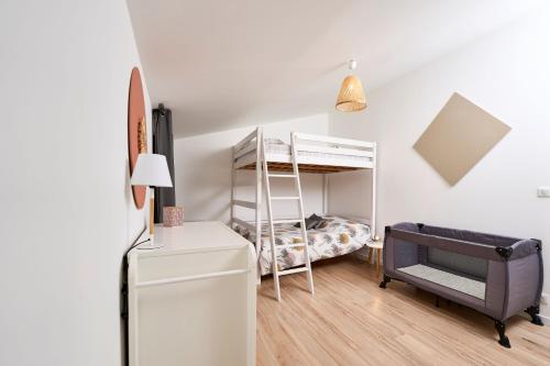 Habitación pequeña con litera y escritorio. en La Velleronnaise, en Velleron