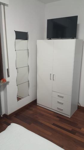 a bedroom with a white cabinet with a television on it at Emil apartment in Novara