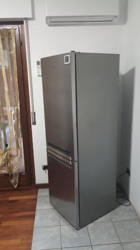 a stainless steel refrigerator in a kitchen next to a door at Emil apartment in Novara