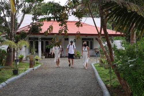 a group of three people walking down a path in front of a house at Shinestar Villa Mirissa in Mirissa