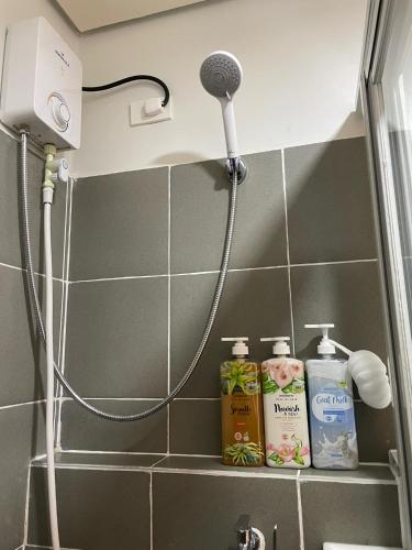 a bathroom with a shower with a blow dryer at Cozy and Affordable Deluxe Condo near Puerto Princessa Airport in Puerto Princesa City