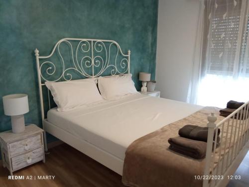 a bedroom with a white bed with a green wall at Casa Tropical in Salobreña