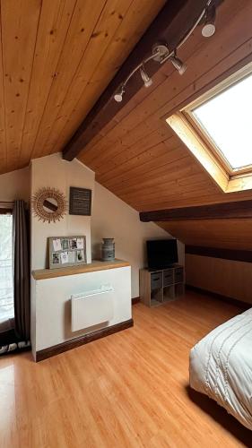 une chambre avec un lit et une lucarne dans l'établissement Maison de vacances avec grand terrain, à Albertville