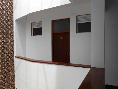 a door in a white wall with a window at Coral Seas Beach Hikkaduwa in Hikkaduwa