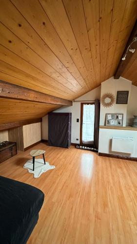 Cette grande chambre dispose d'un plafond en bois et d'une table. dans l'établissement Maison de vacances avec grand terrain, à Albertville
