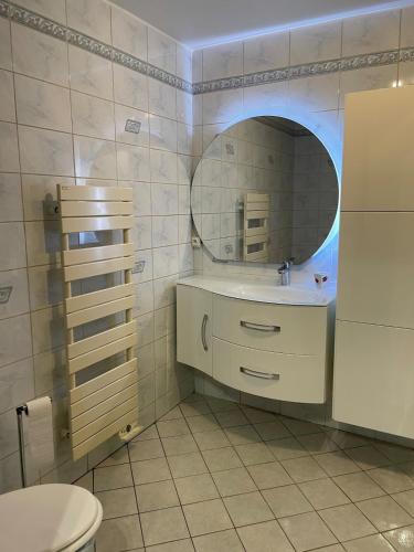 une salle de bain avec un lavabo et un miroir dans l'établissement Maison de vacances avec grand terrain, à Albertville