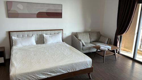 ゲラン・パタにあるCarnelian Tower Hotel at ForestCity 4108 with WIFIのベッドとソファと椅子のある寝室