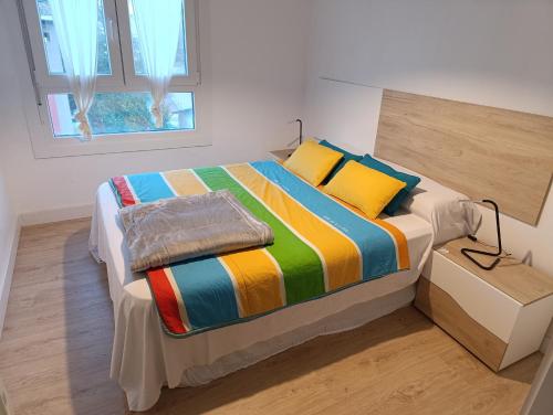 a bedroom with a bed with a colorful comforter at Apartamento 2 habitaciones cerca del puerto de Pasajes in Donostia-San Sebastián