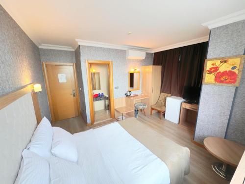 a hotel room with a white bed and a bathroom at Lounge Hotel in Tuzla