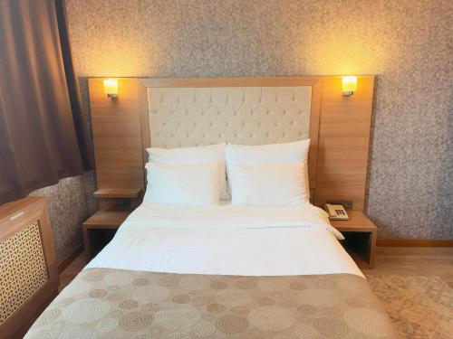 a bedroom with a large bed with white sheets and pillows at Lounge Hotel in Tuzla