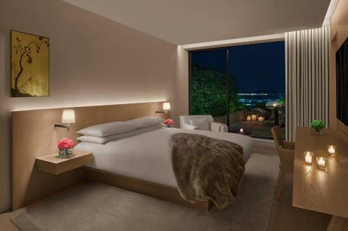 a bedroom with a large bed and a large window at The Tokyo EDITION, Toranomon in Tokyo