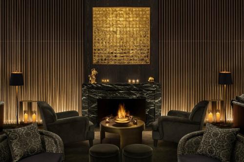a living room with a fireplace and chairs and a table at The Tokyo EDITION, Toranomon in Tokyo