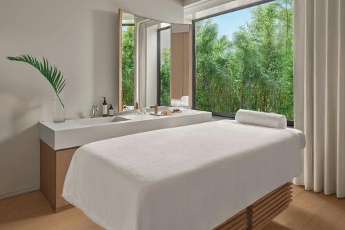 a white bathroom with a large bed and a bath tub at The Tokyo EDITION, Toranomon in Tokyo