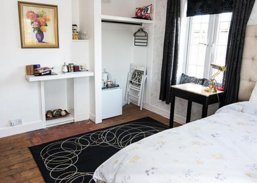 um quarto com uma cama, uma escrivaninha e uma janela em House on the Corner B&B em Didcot