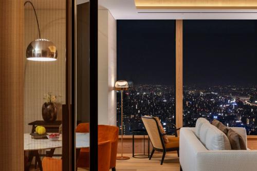 a living room with a view of a city at night at Bvlgari Hotel Tokyo in Tokyo