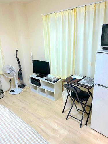 a room with a bed and a desk with a computer at KIYAZA River Sapporo in Sapporo