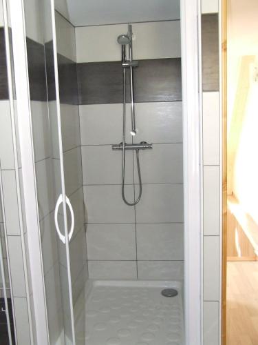 une salle de bain avec une douche avec une porte vitrée dans l'établissement duplex neuf 3etoiles, à Le Mont-Dore