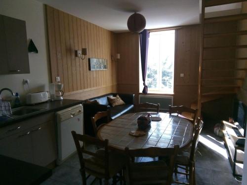 une cuisine avec une table et des chaises et une cuisine avec un canapé dans l'établissement duplex neuf 3etoiles, à Le Mont-Dore