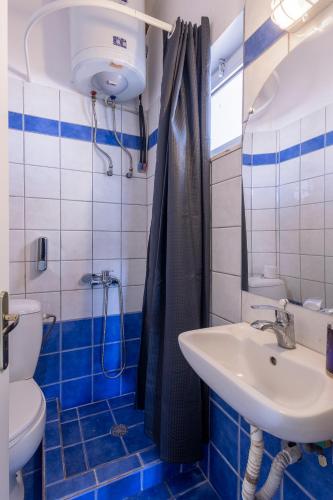 a blue and white bathroom with a sink and a toilet at Secret Oasis Aptms Room 2 in Larisa
