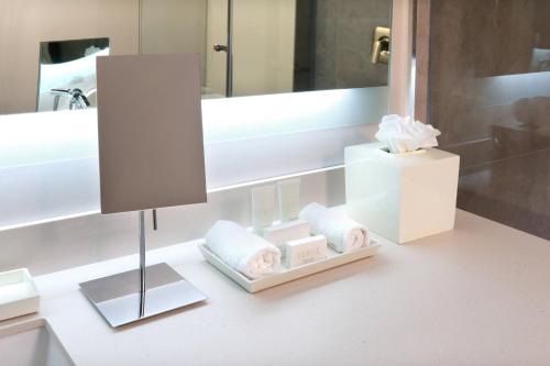 a bathroom with a vanity with a mirror and a lamp at Courtyard Monterrey Airport in Monterrey