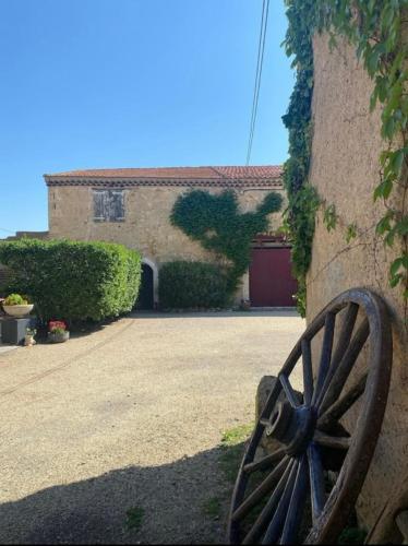 a wooden wheel sitting in front of a building at Gite au cœur des vignes in Béziers