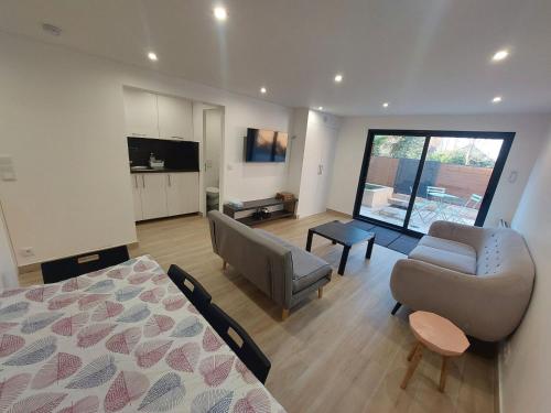 Μια τηλεόραση ή/και κέντρο ψυχαγωγίας στο Appartement avec terrasse dans la verdure