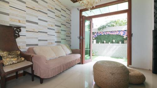 a living room with a couch and a chair at RedDoorz Hostel @ St. Paul Village LapuLapu in Mactan