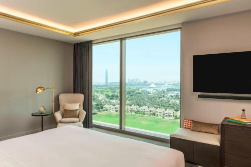 a hotel room with a bed and a large window at Aloft Dubai Creek in Dubai
