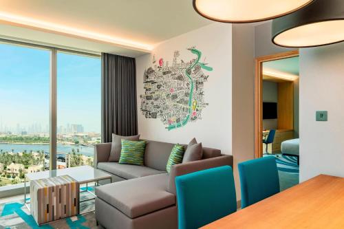 a living room with a couch and a table at Aloft Dubai Creek in Dubai