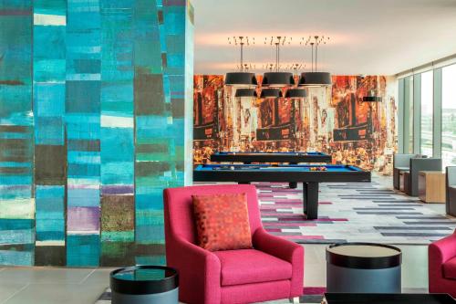 a lobby with a ping pong table and a pink chair at Aloft Dubai Creek in Dubai