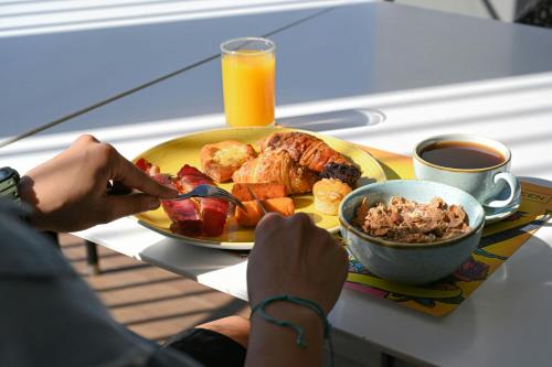 a person eating a breakfast plate of food on a table at Aloft Dubai Creek in Dubai