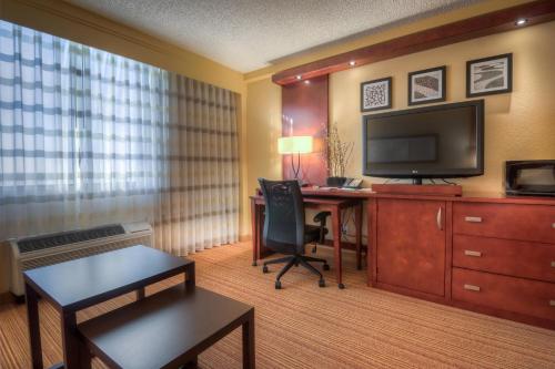 a hotel room with a desk and a television at Courtyard by Marriott Killeen in Killeen