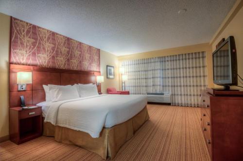 a hotel room with a large bed and a television at Courtyard by Marriott Killeen in Killeen