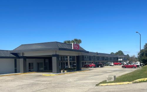Un edificio con un estacionamiento enfrente. en Red Roof Inn Slidell, en Slidell