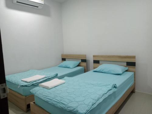 twee bedden naast elkaar in een kamer bij Lamai Home 2 in Ko Yao Noi
