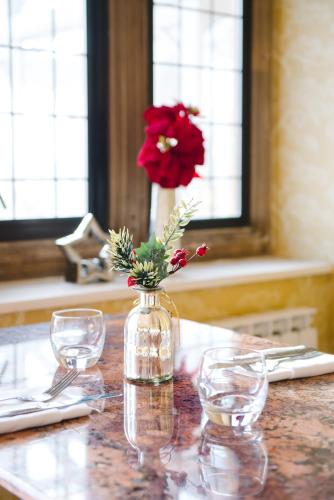 a vase with a red flower in it on a table at Cricklade House Hotel, Sure Hotel Collection by Best Western in Cricklade
