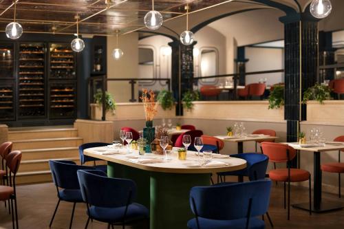 a restaurant with tables and chairs and lights at Duo Milan Porta Nuova, a Tribute Portfolio Hotel in Milan