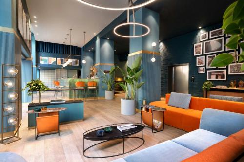 a living room with an orange couch and a table at Duo Milan Porta Nuova, a Tribute Portfolio Hotel in Milan