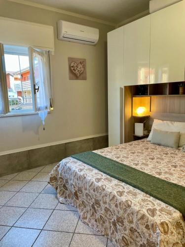 a bedroom with a bed and a window at Bnbook Lago Magico in Dormelletto