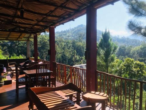 um alpendre com cadeiras e mesas e vista para as montanhas em Turn View Resort Ella em Ella