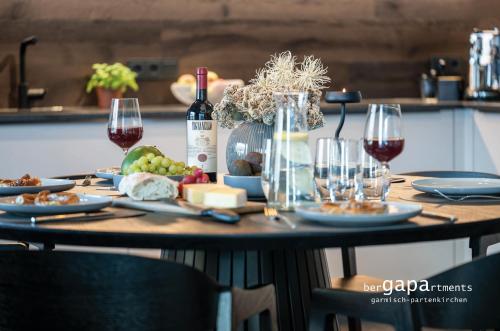 een tafel met een fles wijn en wijnglazen bij BergHome in Garmisch-Partenkirchen