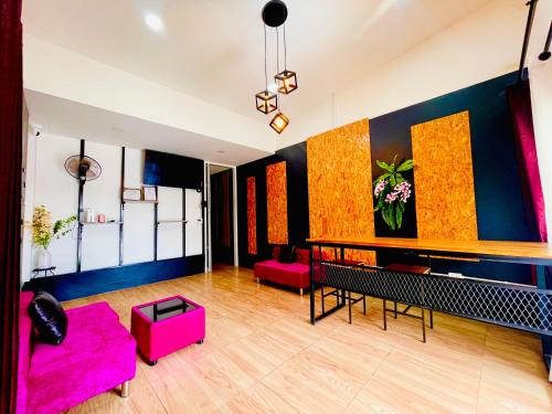 a living room with a pink couch and a table at Lamai Home1 in Ko Yao Noi