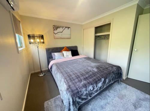 a bedroom with a bed and a lamp in it at Perfect room in Wantirna in Wantirna