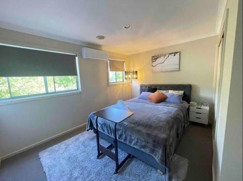 a bedroom with a bed with a table and a window at Perfect room in Wantirna in Wantirna